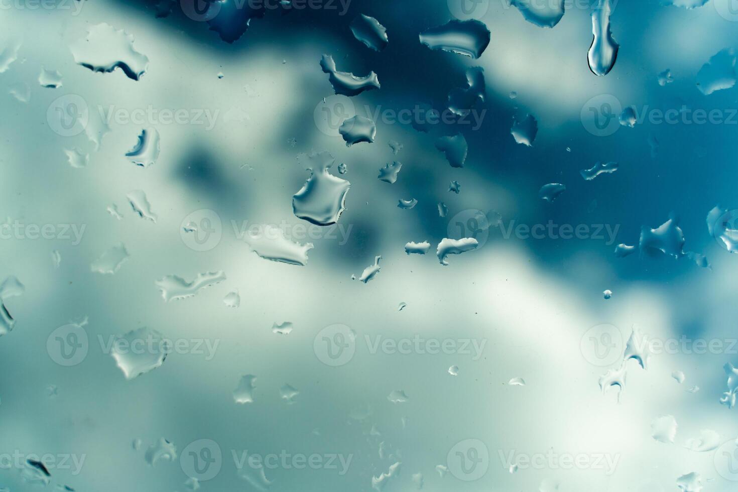 Water drops on glass against blue sky. Window view background screensaver. Place for text banner. photo
