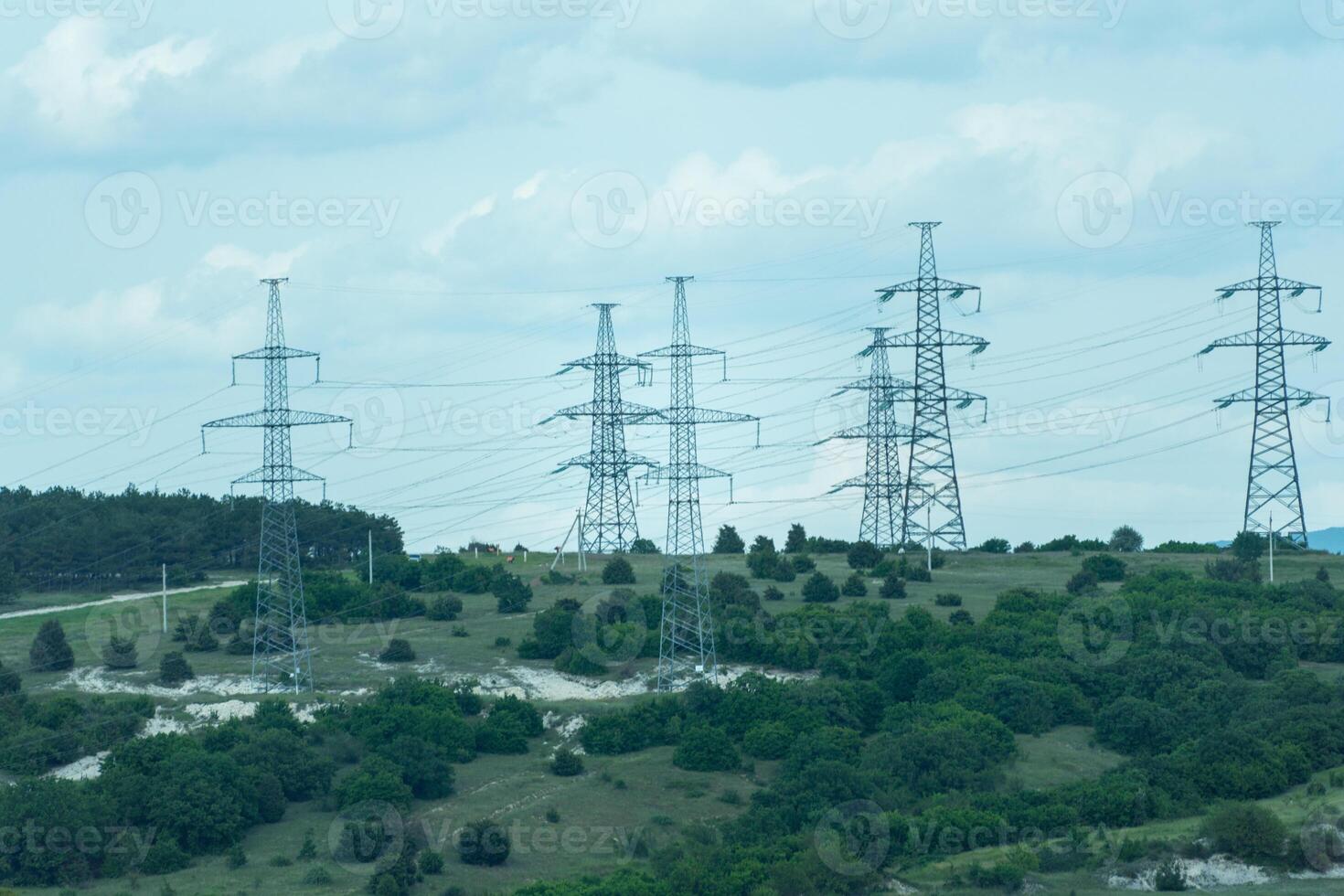 High voltage towers with sky background. Power line support with wires for electricity transmission. High voltage grid tower with wire cable at distribution station. Energy industry, energy saving photo