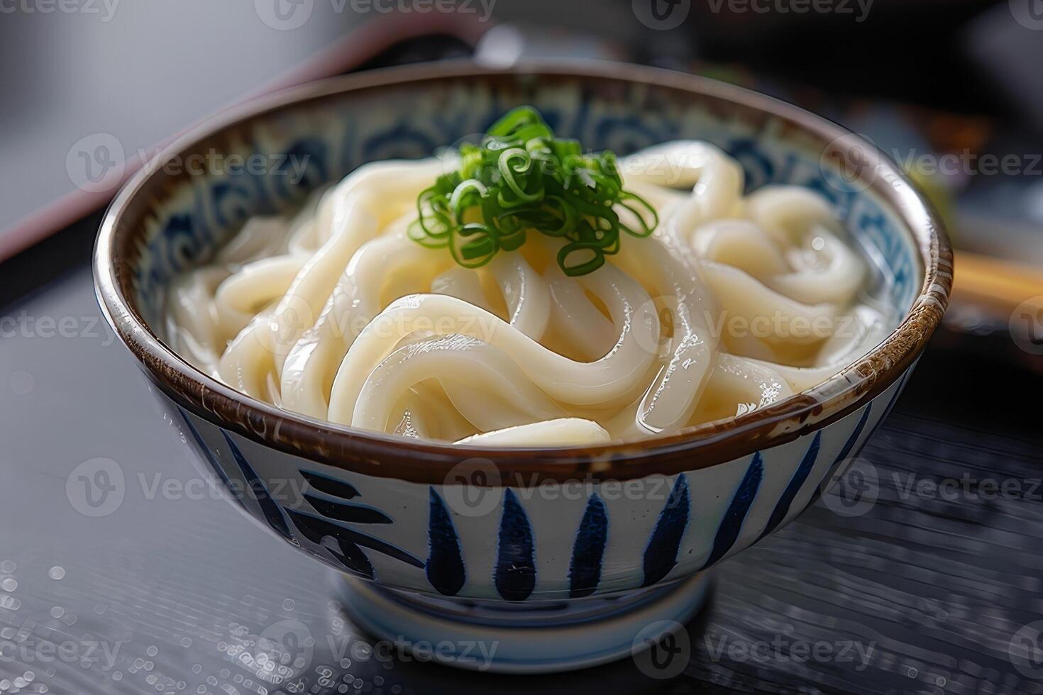 Japanese udon noodles in a bowl on a wooden table close up photo