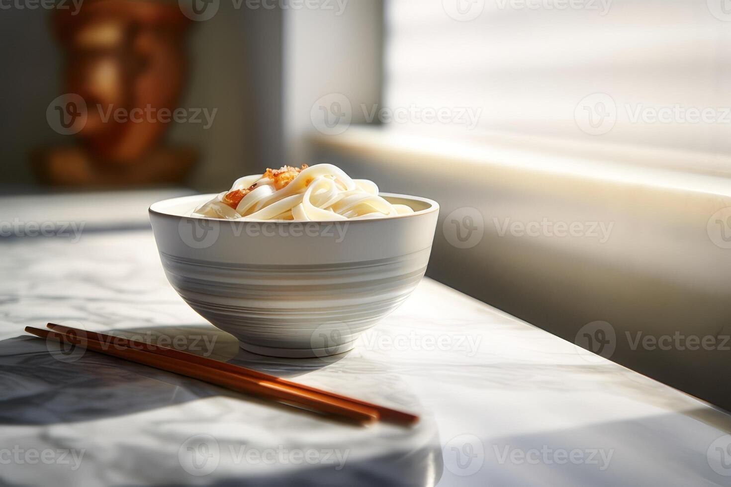 Japanese udon noodles in a bowl with chopsticks on a white table photo