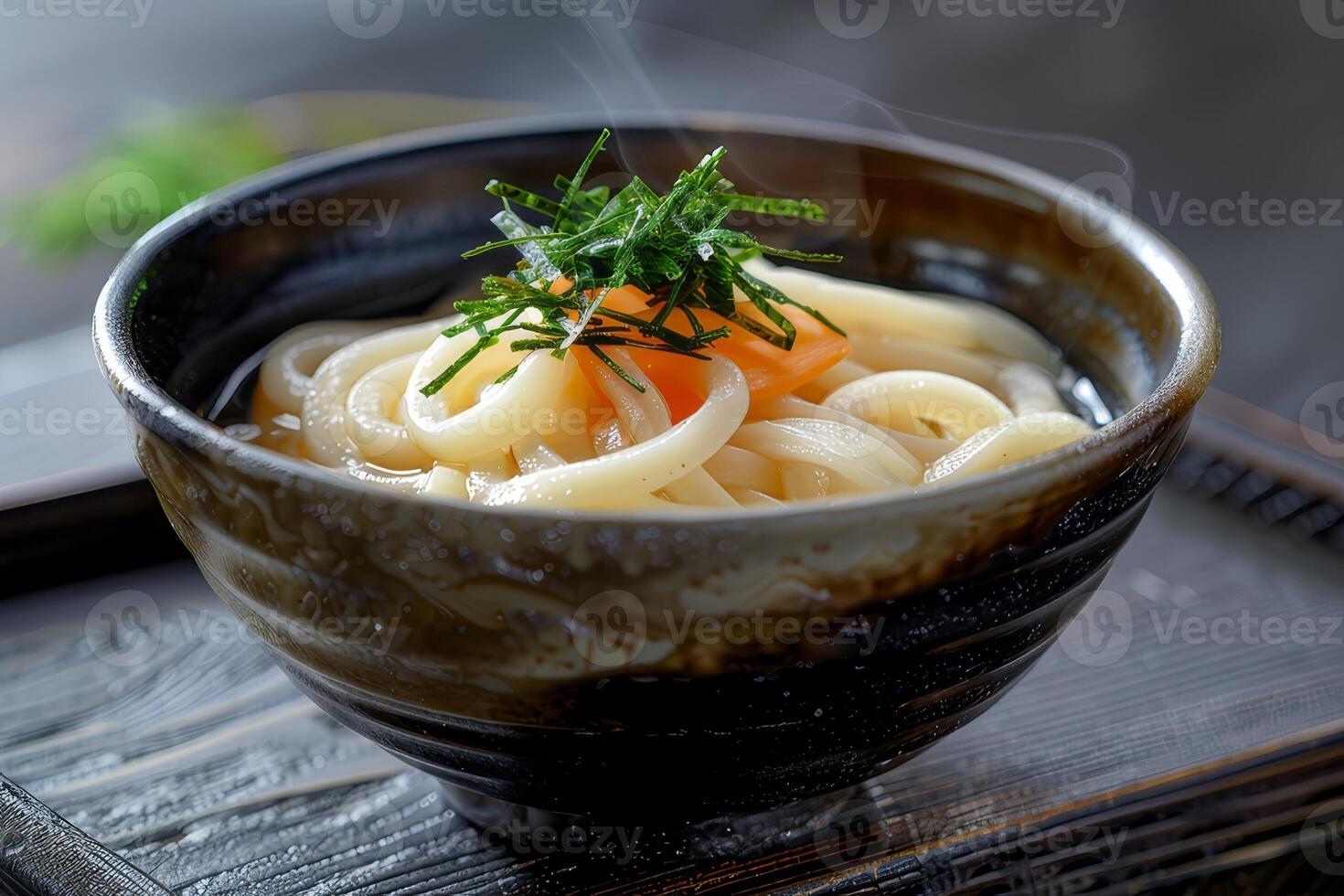 Japanese udon noodles in a bowl on a wooden table close up photo