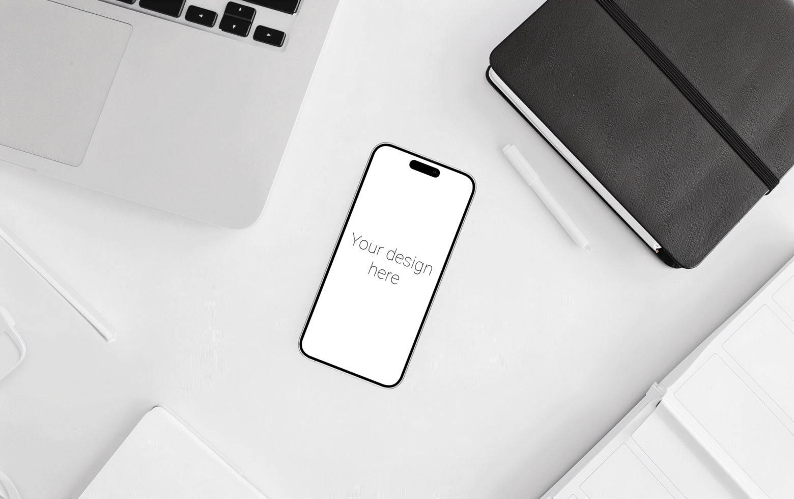Mockup of white smartphone similar to iphone 15 lies on white table. Laptop and notebook next to each other psd