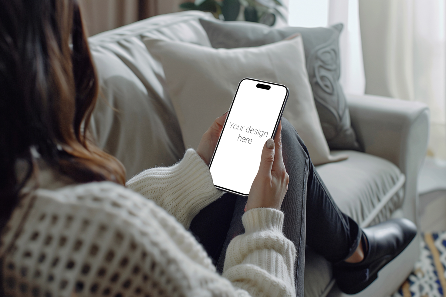 Mockup of white smartphone similar to iphone 15 in person's hand. Person sitting on the sofa psd