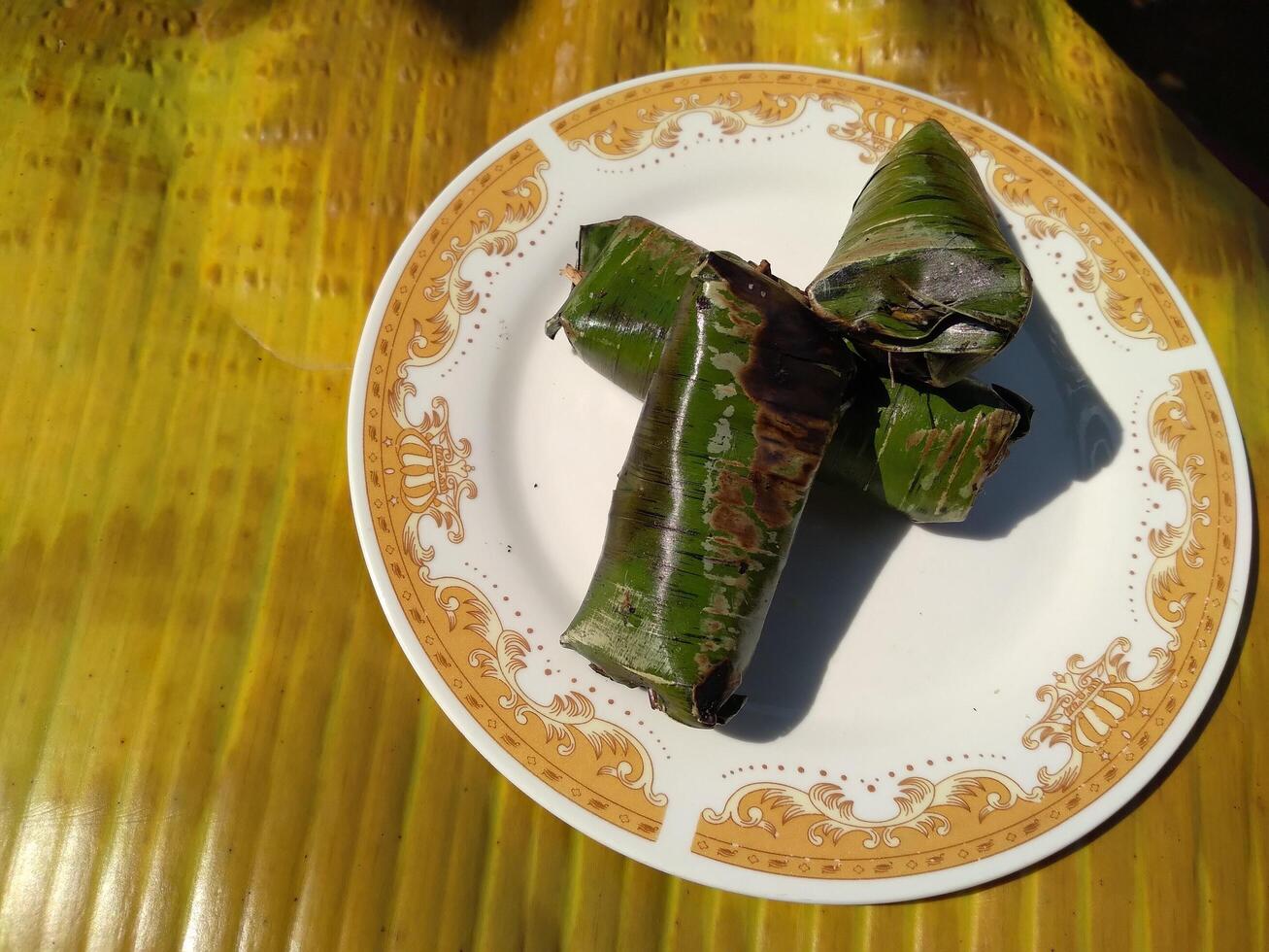 Indonesian tradisional food called lemper made from steamed glutinous rice with chicken meat wrapped with banana leaf photo