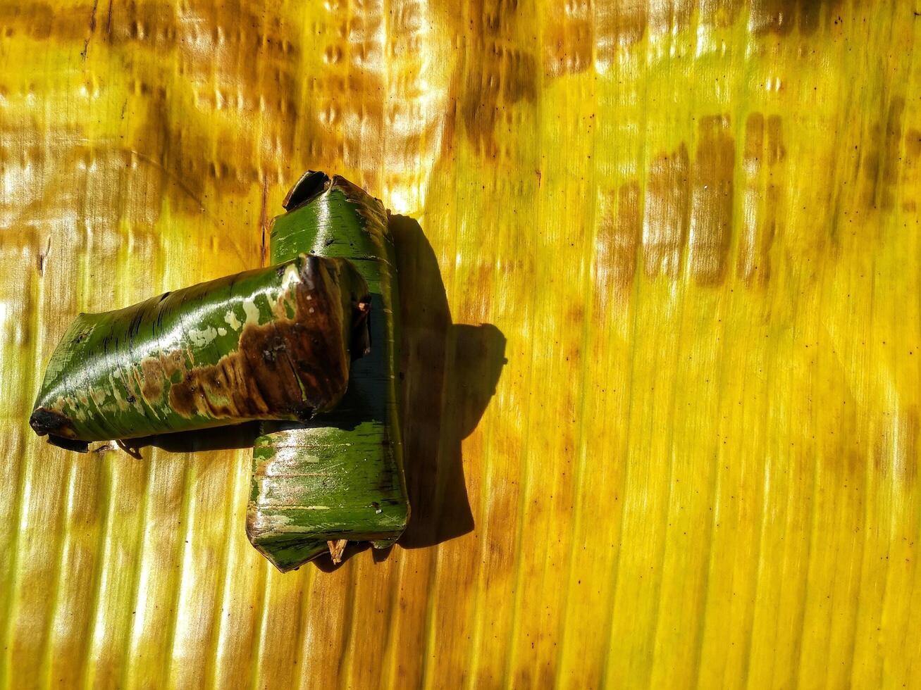 Indonesian tradisional food called lemper made from steamed glutinous rice with chicken meat wrapped with banana leaf photo