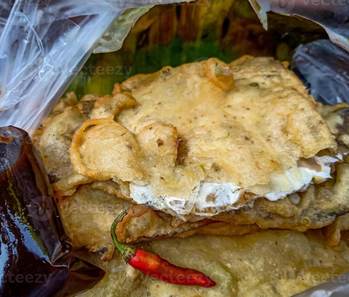Tempe Mendoan is a traditional food made from tempeh covered in flour batter with a mixture of sliced leeks and spices. cooked by frying. Selective fokus. photo