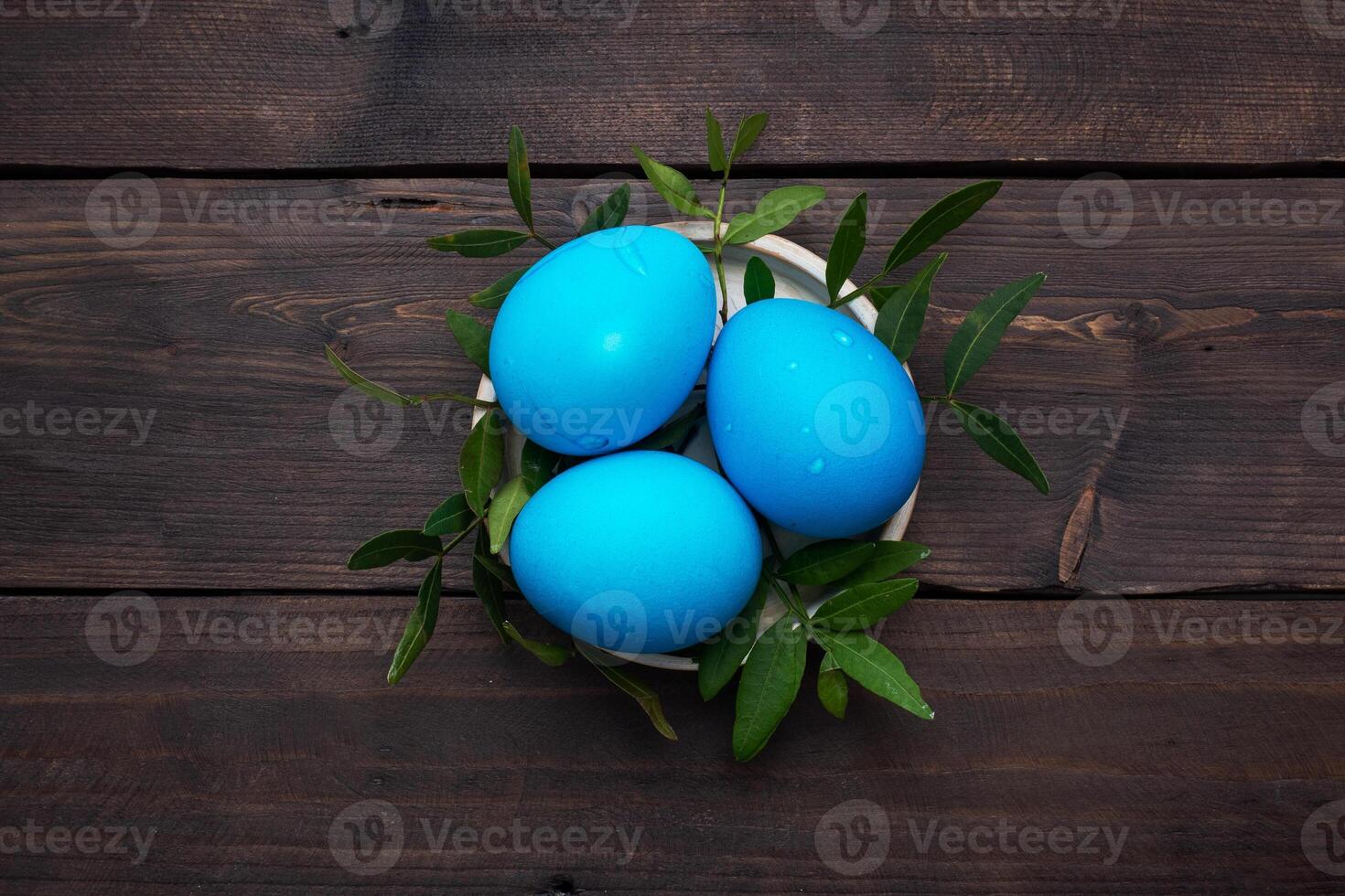 Easter eggs painted by hand colored on a dark wooden table, top view, copy space. photo