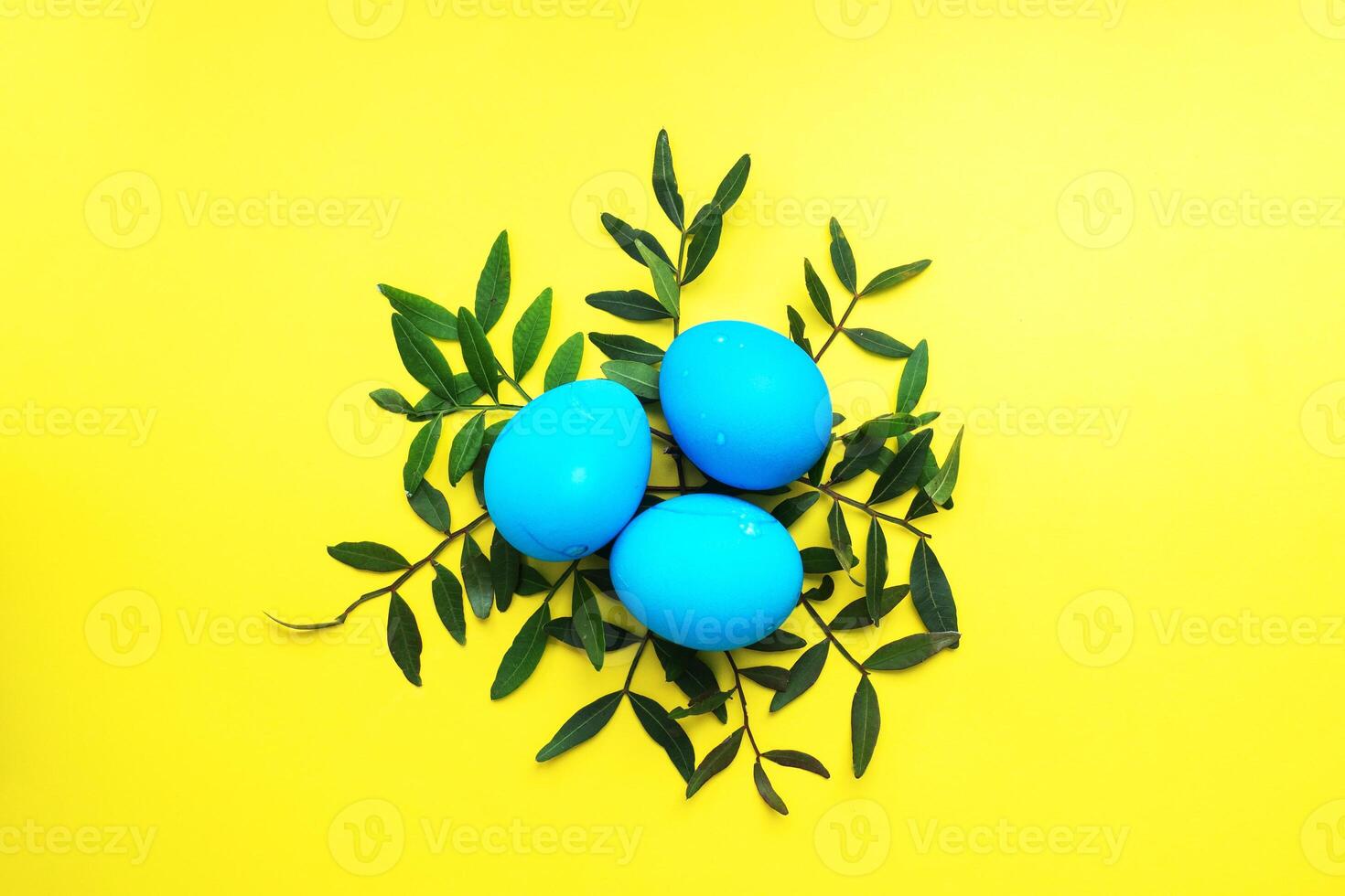 Easter eggs painted by hand colored on a yellow table, top view, copy space. photo