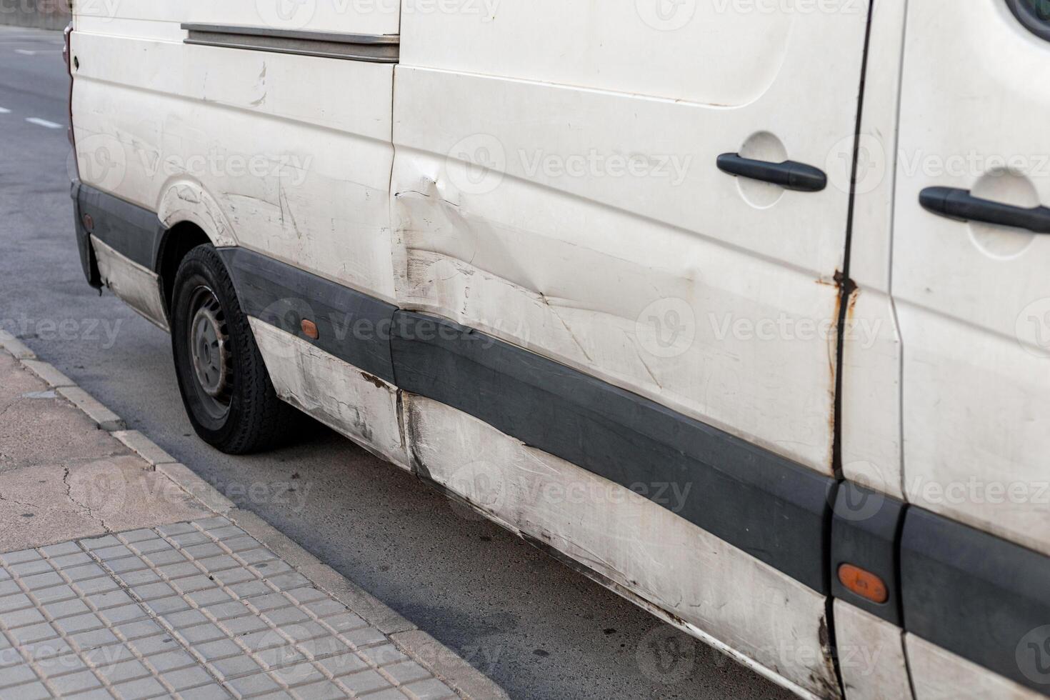 Detailed close-up of a white car with visible damage on its side, featuring dents and scratches. Perfect for showcasing the need for vehicle repairs, insurance case studies, and urban driving risks. photo