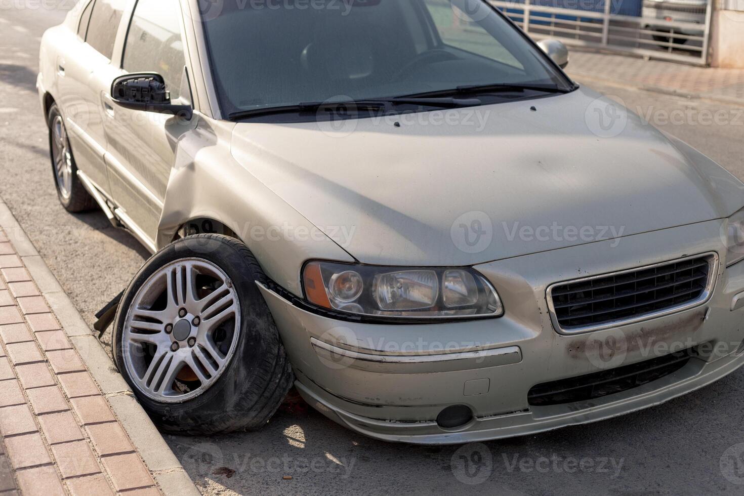 Severe damage to grey car's side after a collision, showcasing a crumpled door and detached bumper. Ideal for use in insurance claims, automotive repair tutorials, and road safety awareness materials. photo