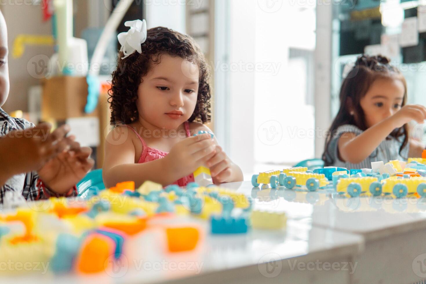 Hispanic little girl Preschool playing with colored blocks in a Kindergarten photo