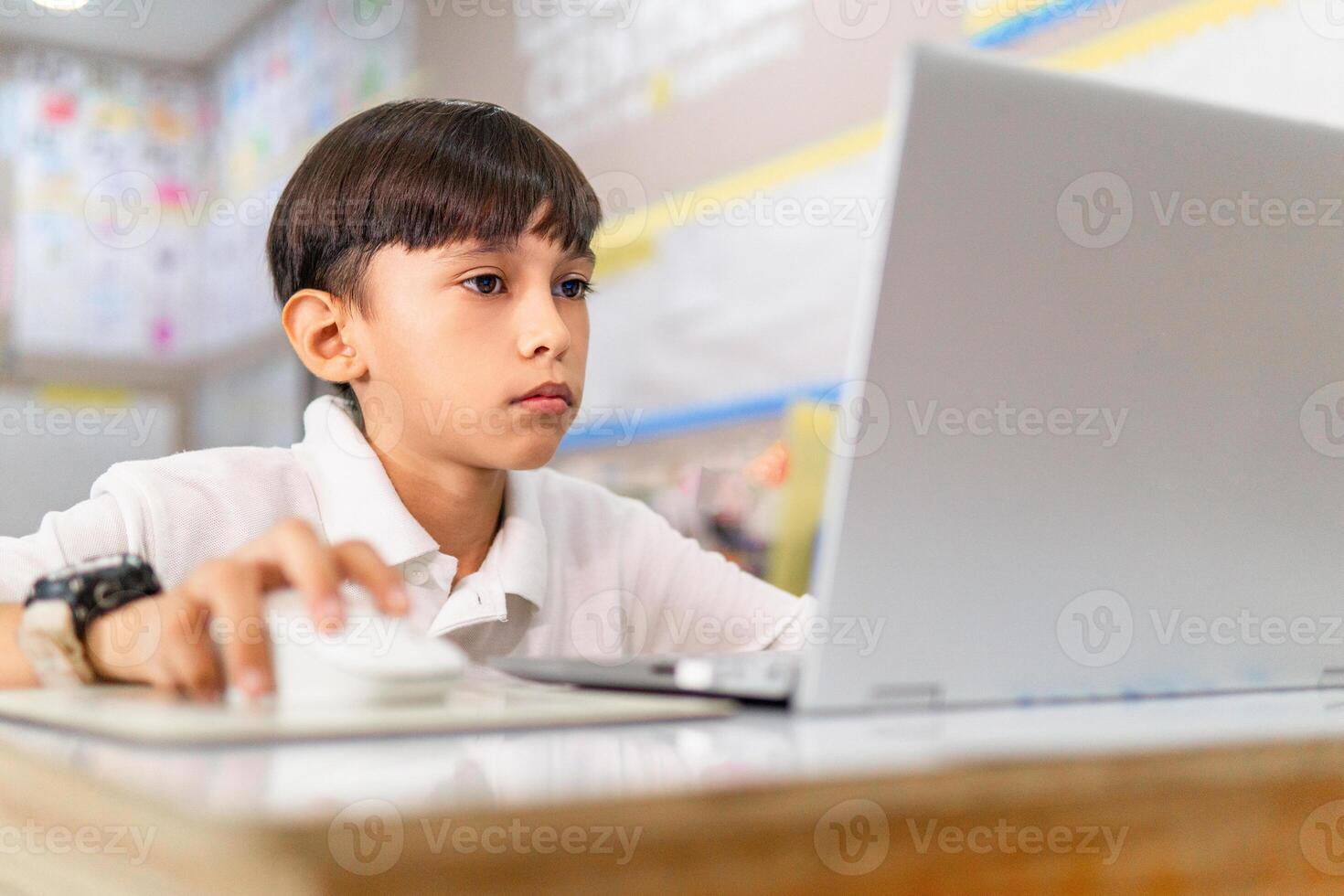 Portrait of little boy using laptop, studying online. photo