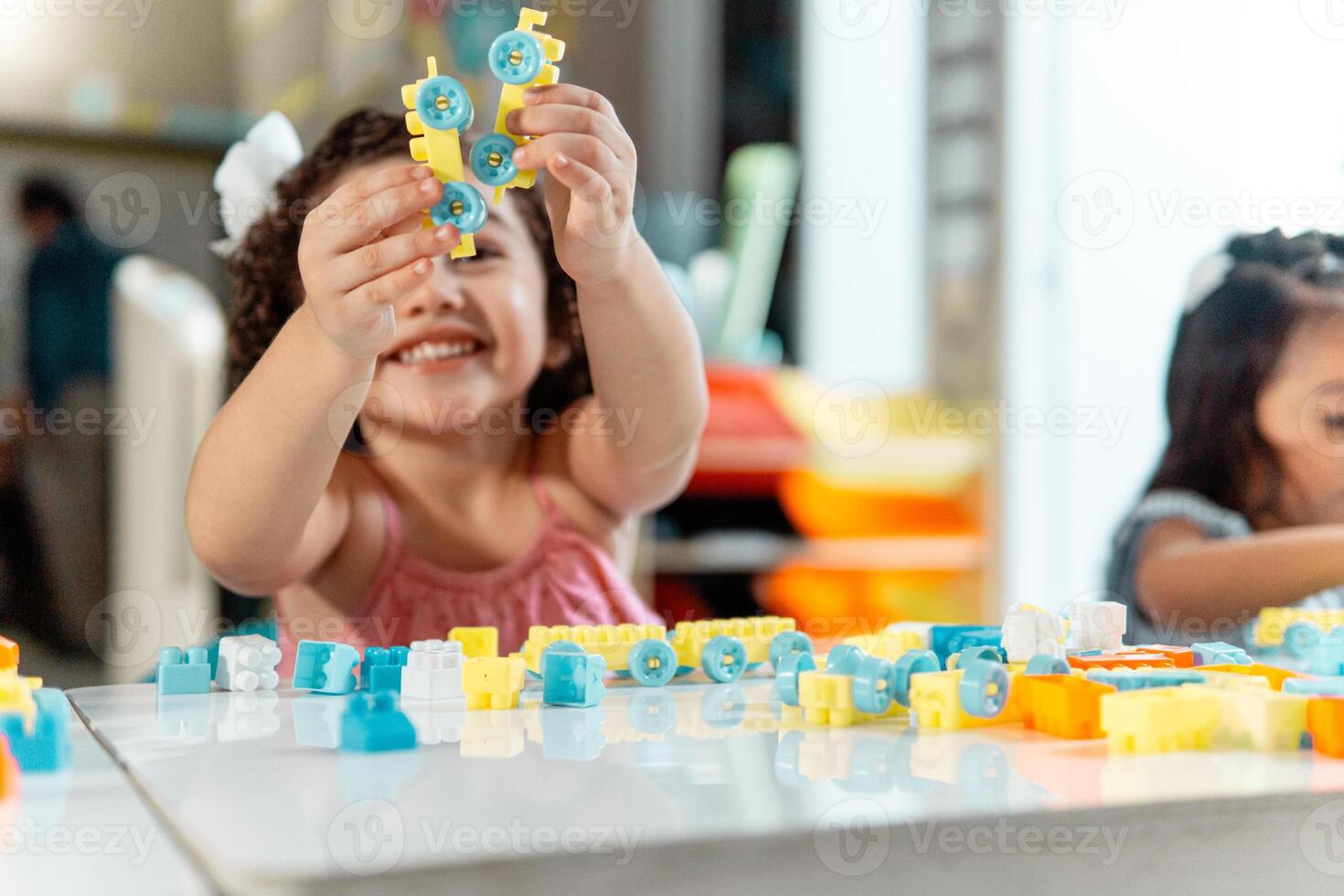 portrait of latin american little child playing with colored block photo