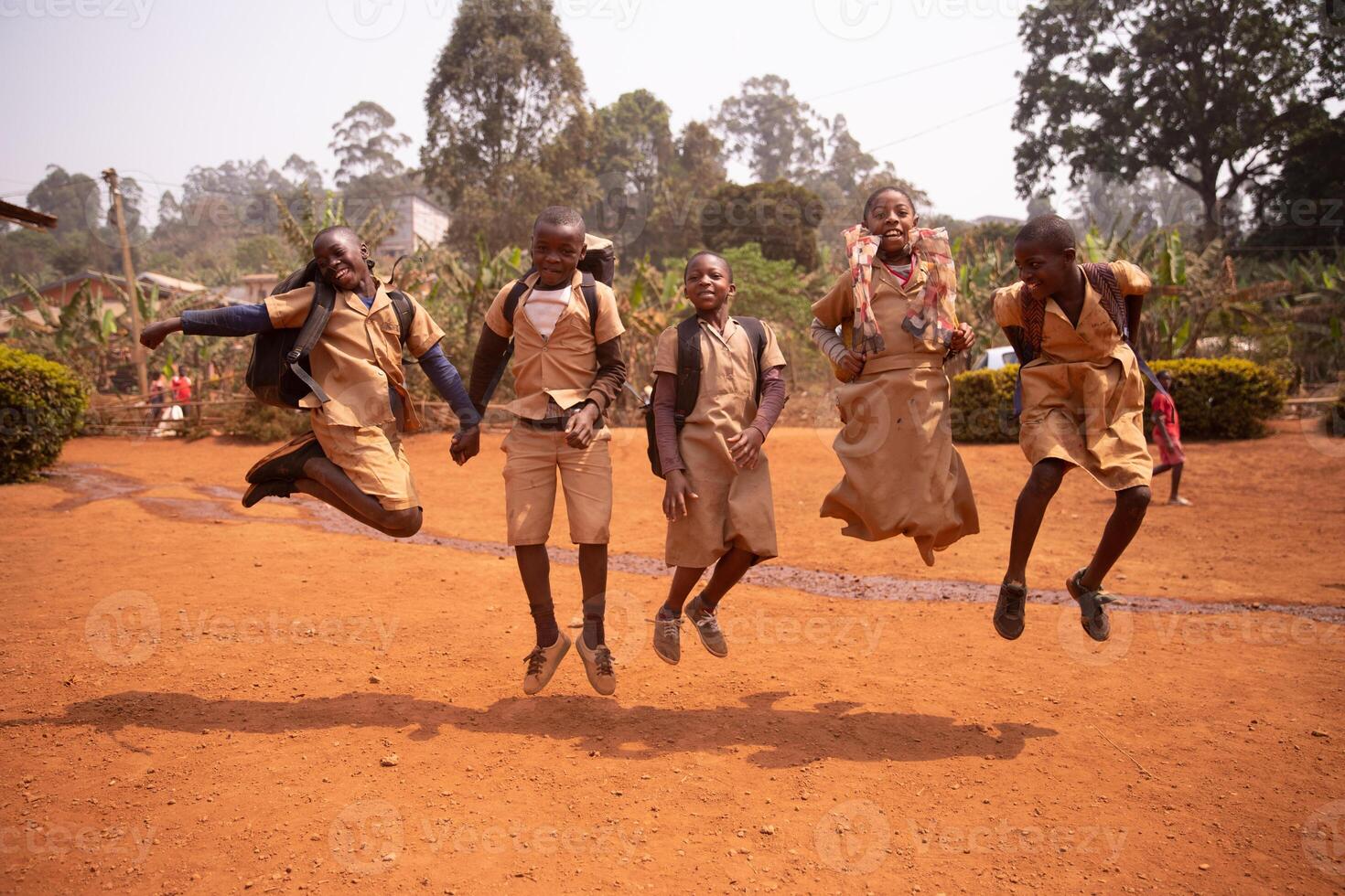Group of african children playing and jumping up and down in the schoolyard. Playing together photo