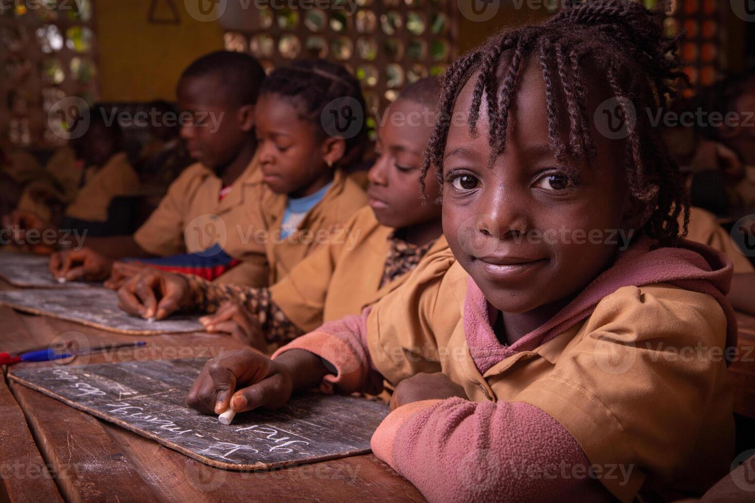 Students in a school in africa take the lesson and write notes on a blackboard with chalk. Children at school in Africa photo