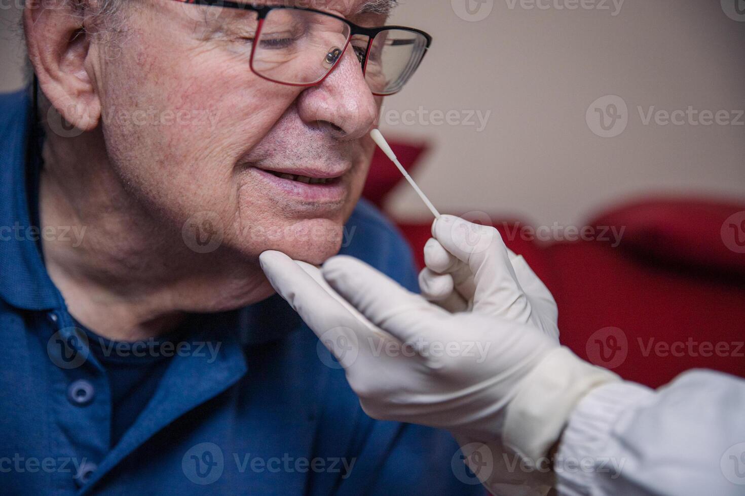 Close-up of an elderly patient being tested for covid-19 with a molecular swab on his nose photo