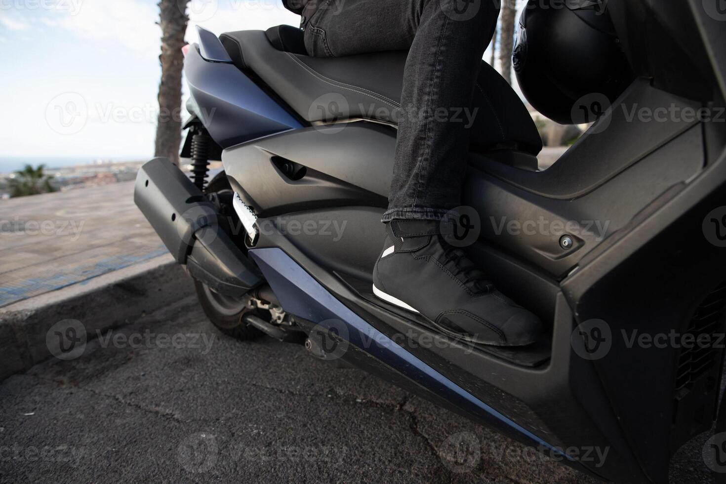 Close-up of the protective shoes of a biker riding on his scooter. photo