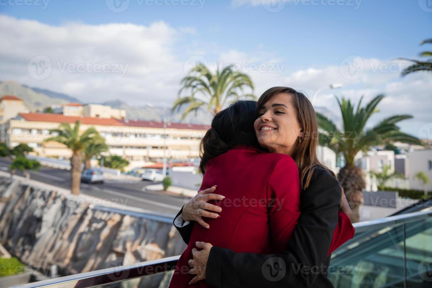 Two female co-workers of different ethnic backgrounds high each other at the business building photo