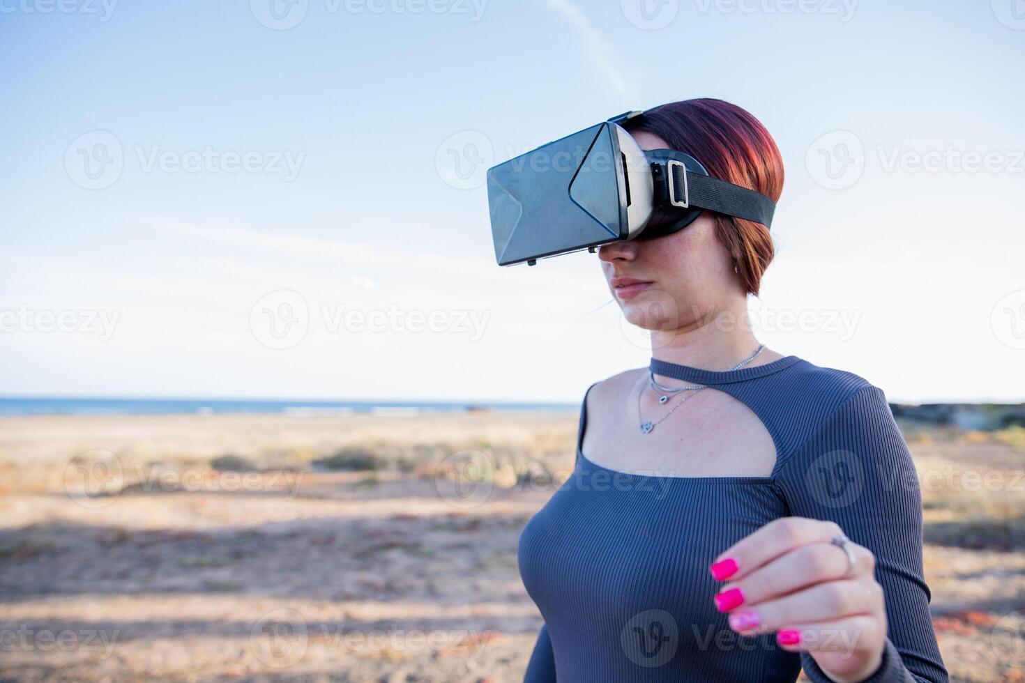 A tourist uses virtual reality headsets while at the beach, technology on vacation photo