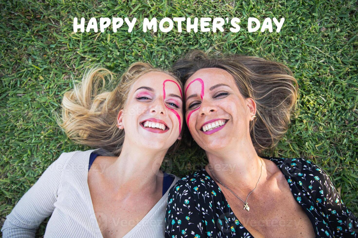 Happy mother's day, smiling mother and daughter with a heart drawn on their faces photo
