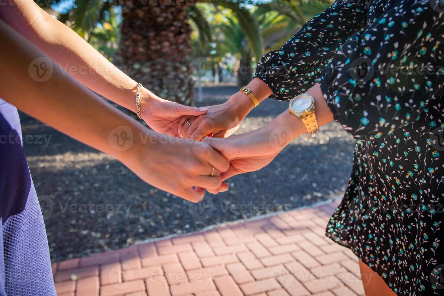 Two women are holding hands, concept of unity and support between females photo