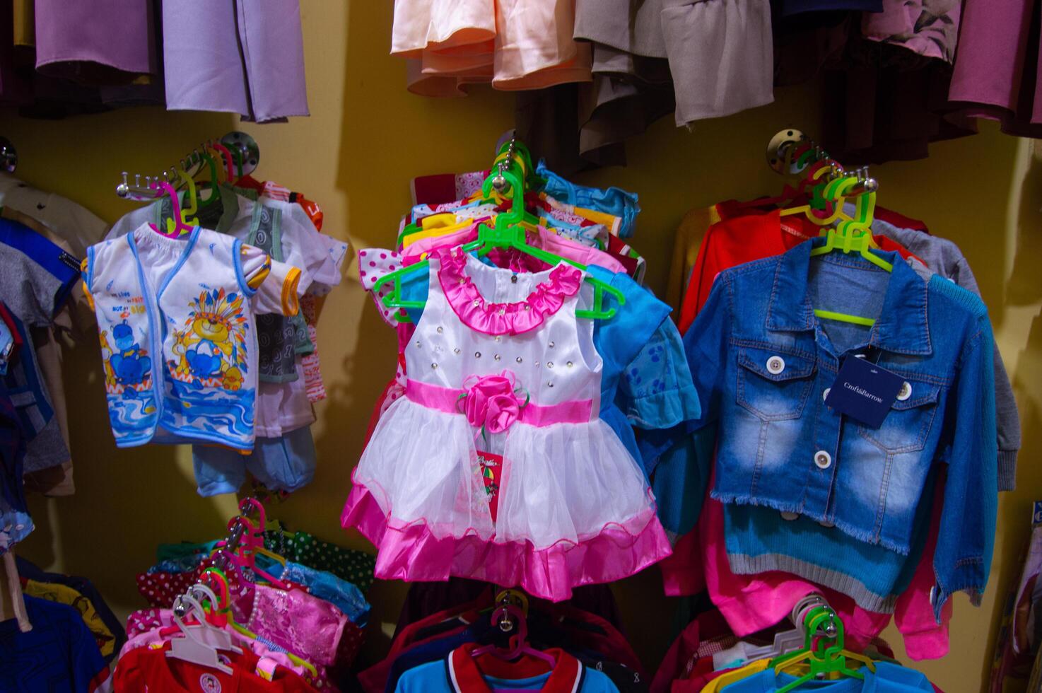 Gresik, Indonesia, March 20, 2023 - Children's clothes are hung inside the shop photo