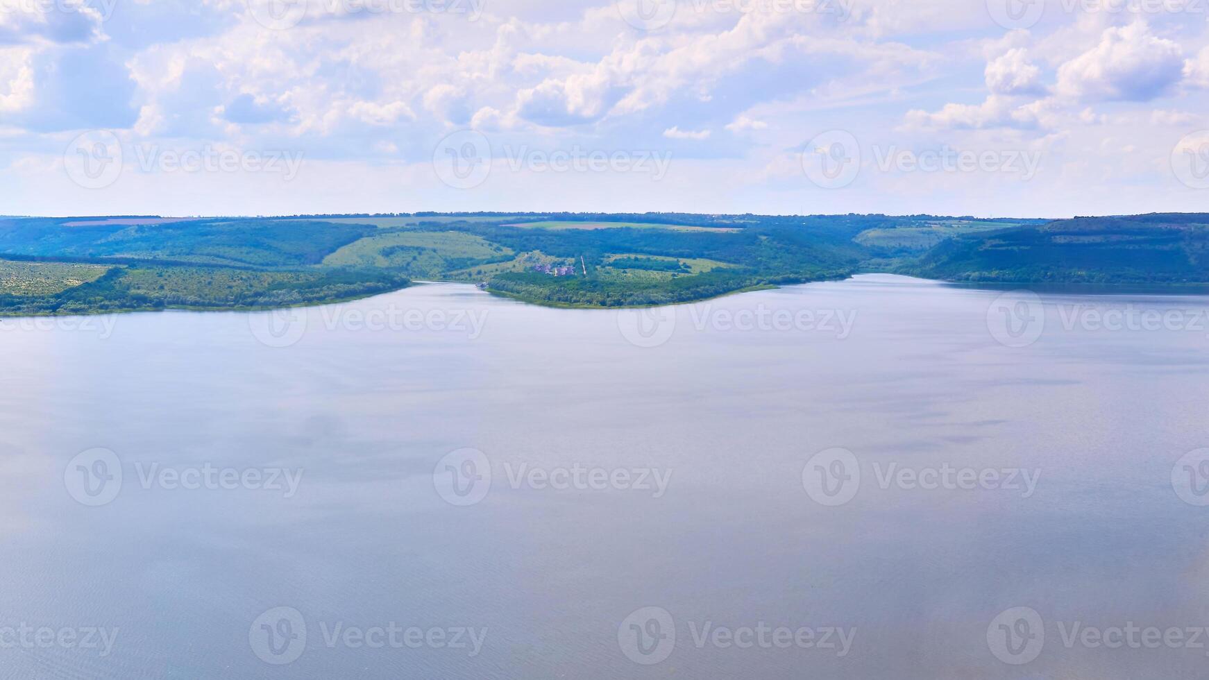 Wide panorama of the river with hilly green banks photo