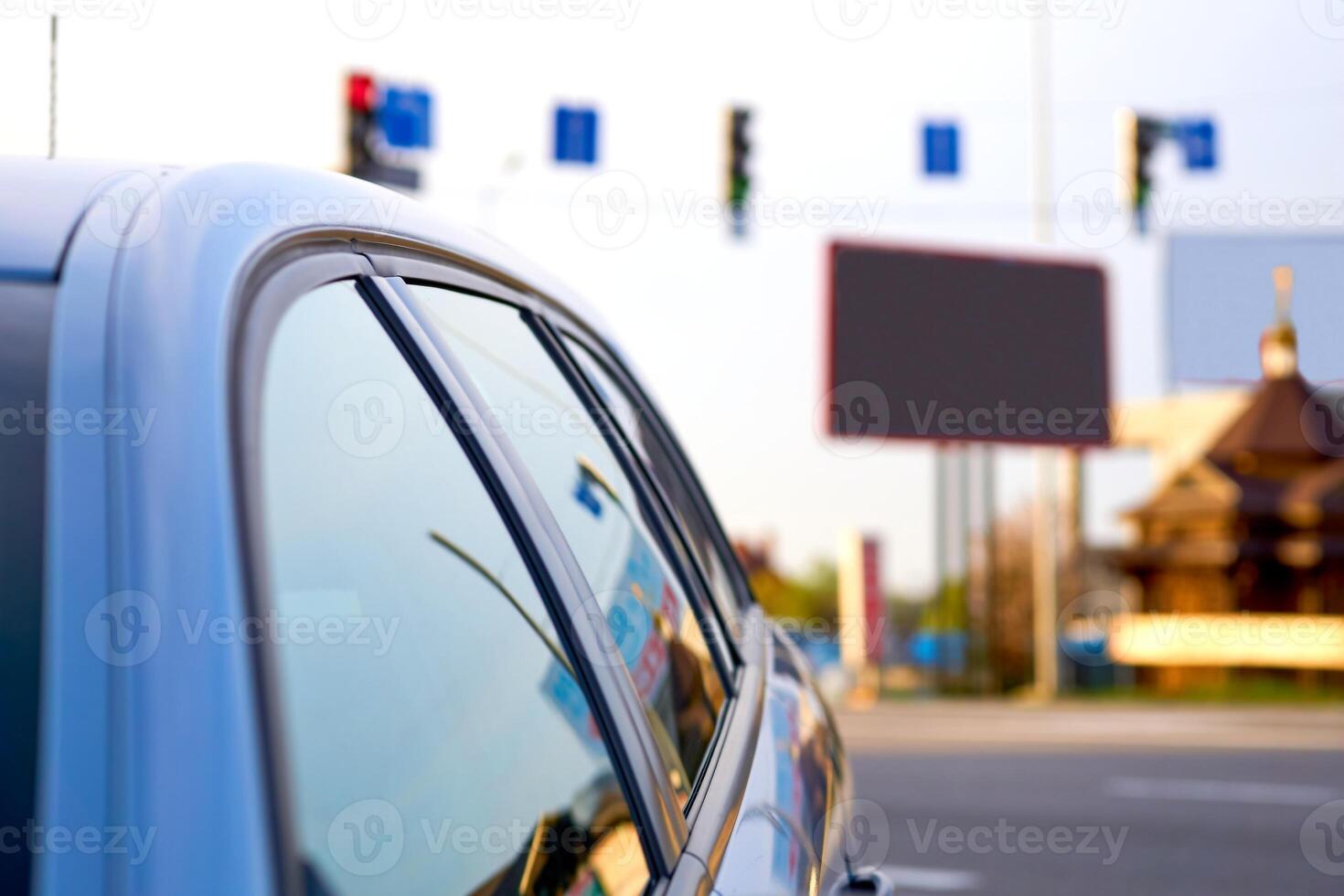 A car standing at an intersection waiting for a green traffic light photo