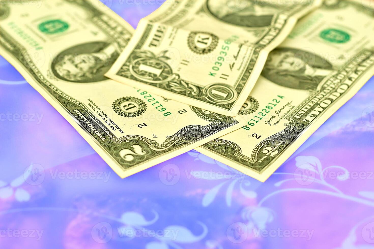 Paper currency.Denominations of one, two dollar banknotes on pink blue surface photo
