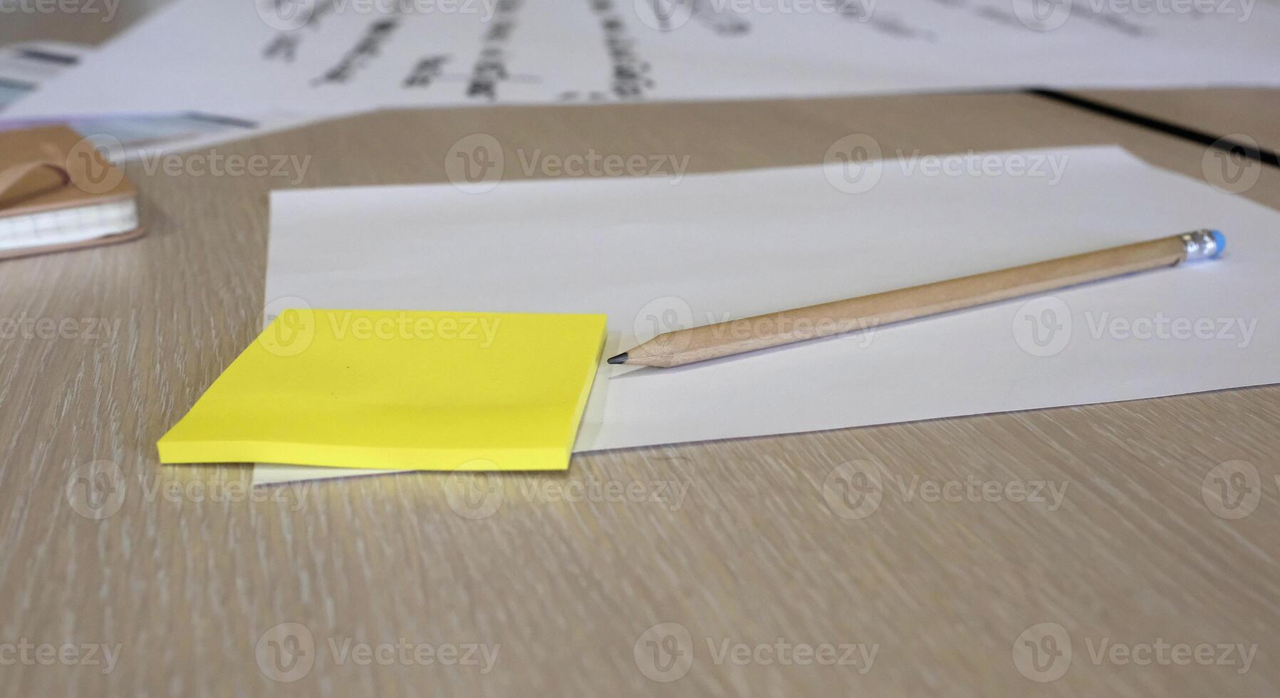 Post it notes, papers and a pencil during a brainstorming session at a business workshop photo