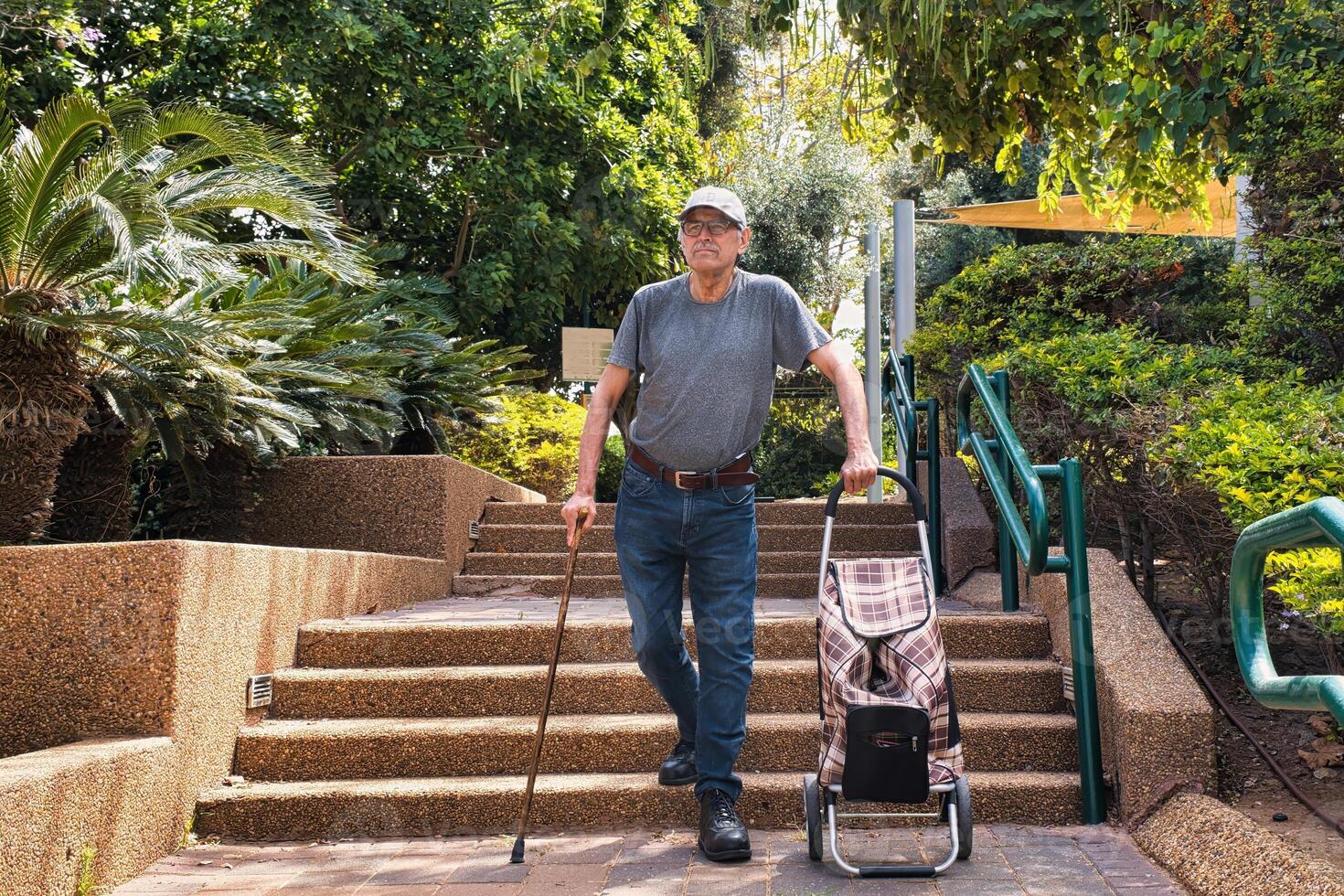 Elderly man walking down the stairs with a walking stick. photo