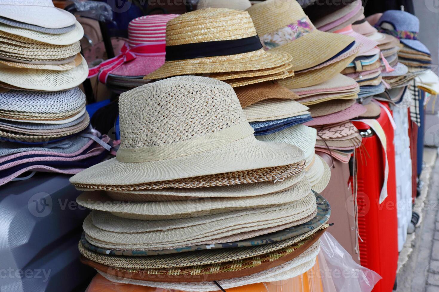 A row of summer hats arranged in different colors and styles displayed on the market stall. The hats are sorted in a way that helps customers to browse and choose the one they like. Selective focus. photo