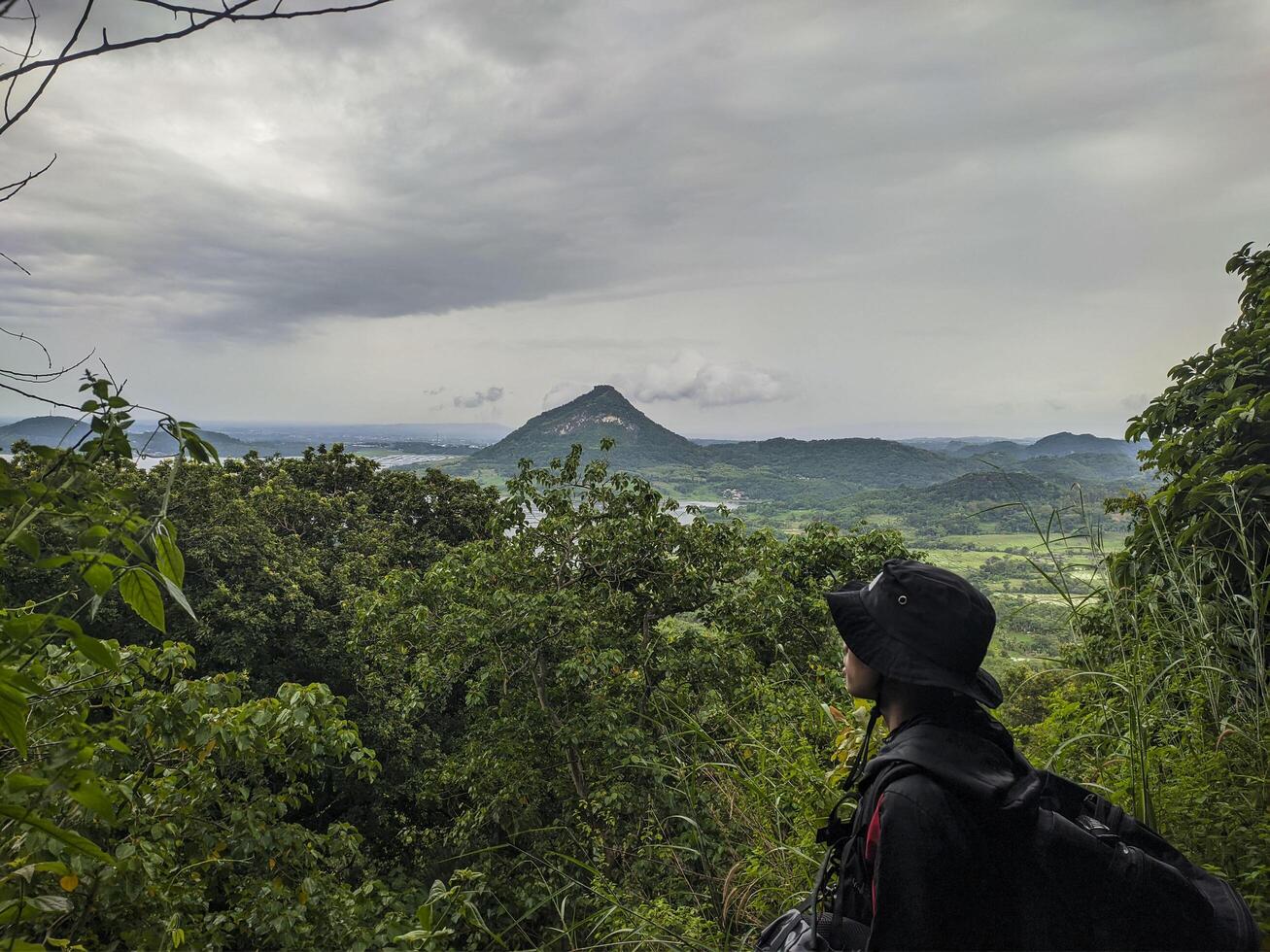 a person with a backpack looking out over the mountains photo
