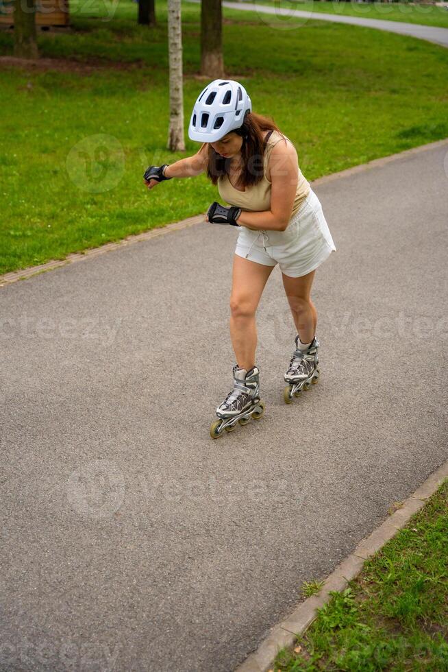 Roller skater woman in park rollerblading on inline skates. Outdoor activities. Summer roller skating. High quality photo