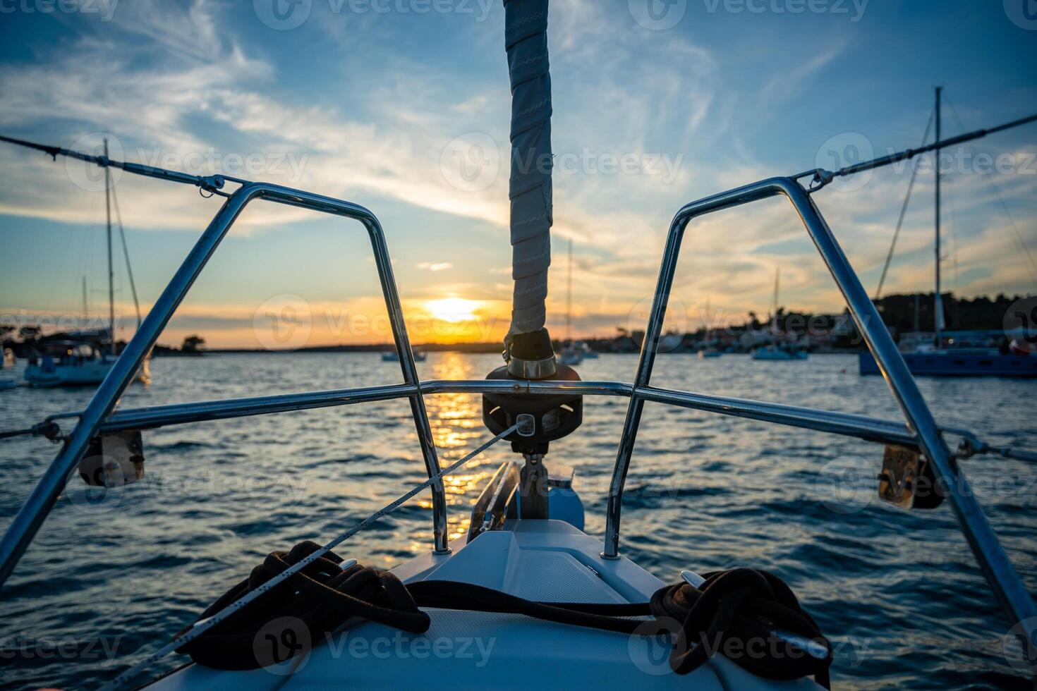 Yacht moored on buoys near the shore in the bay of Uvala Gradina near the town of Vela Luka on the island of Korcula at sunset lights in Croatia. High quality photo