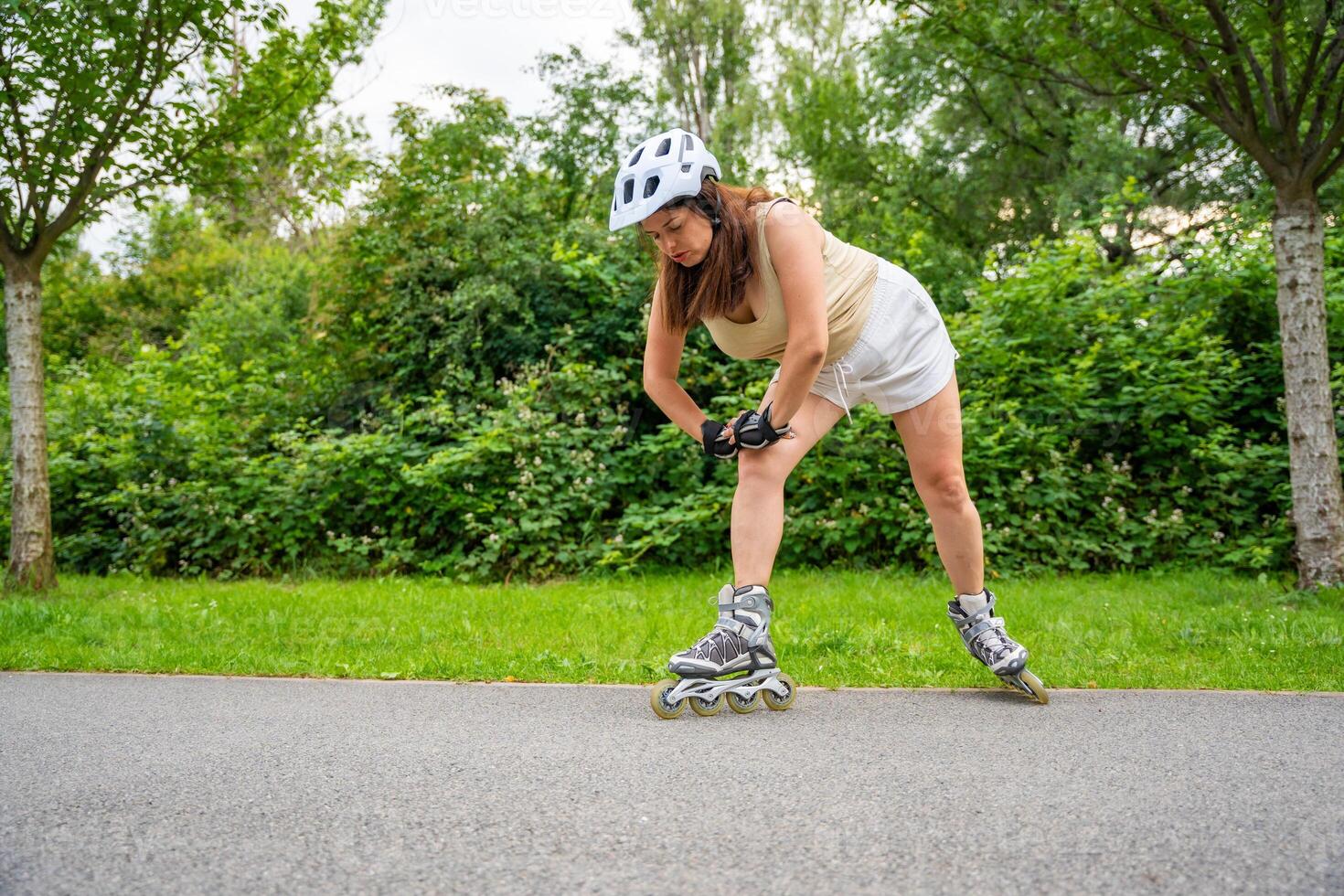 Roller skater woman warming up in park before rollerblading on inline skates. Outdoor activities. Summer roller skating. High quality photo