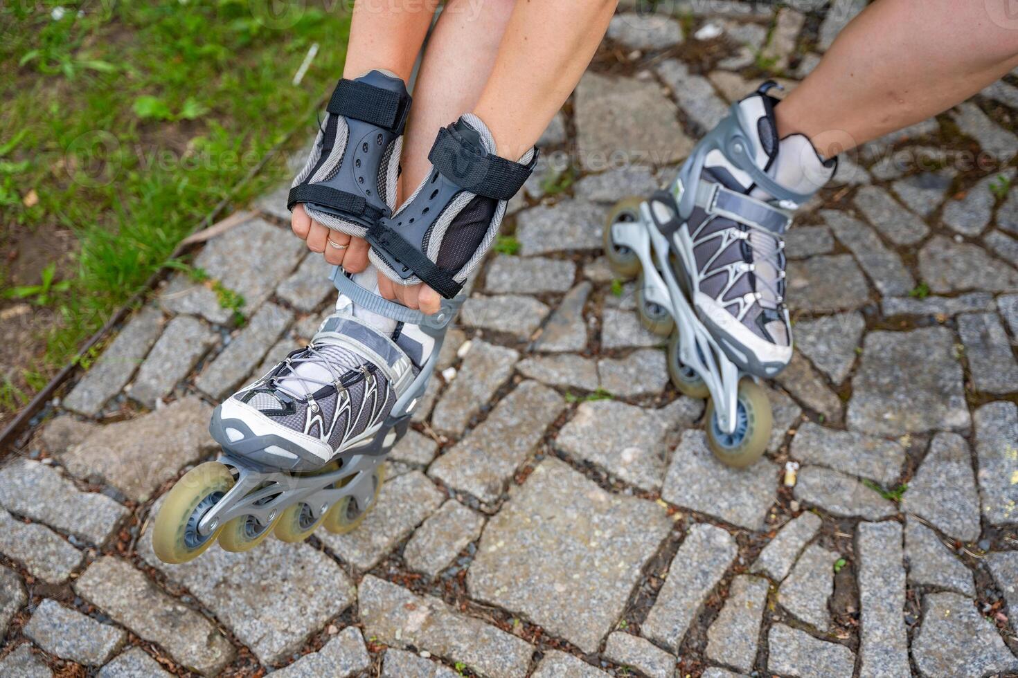Close up view of feet in inline skates of roller skater woman. Rollerblading in park. Outdoor activities. Summer roller skating. High quality photo