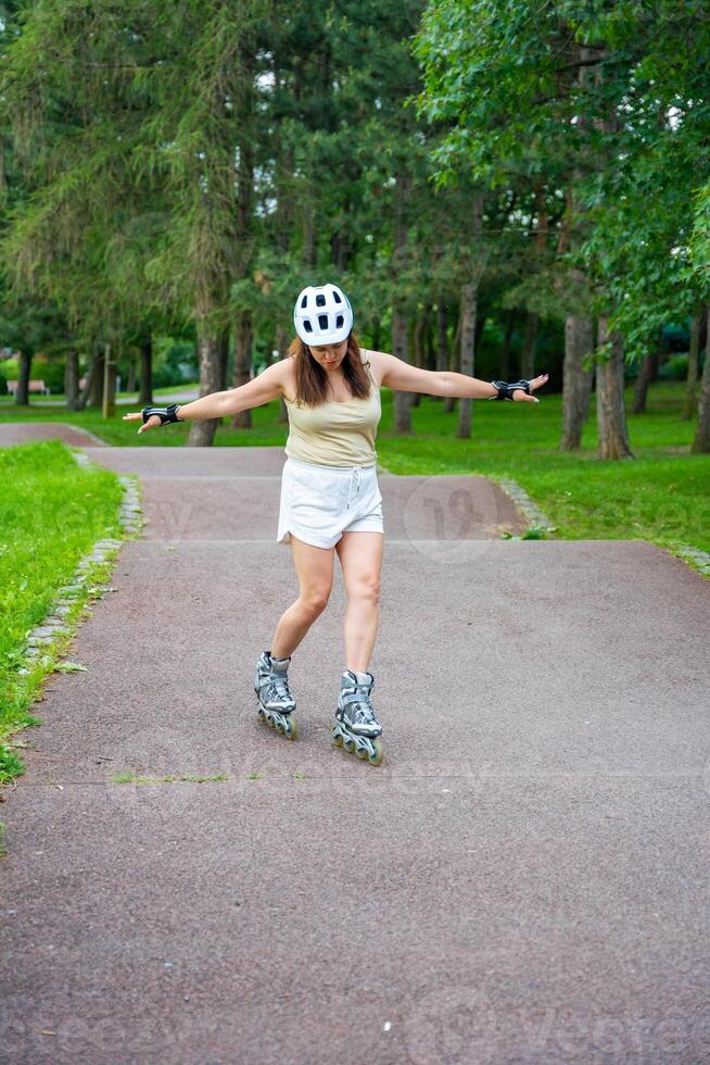 Roller skater woman in park rollerblading on inline skates. Outdoor activities. Summer roller skating. High quality photo