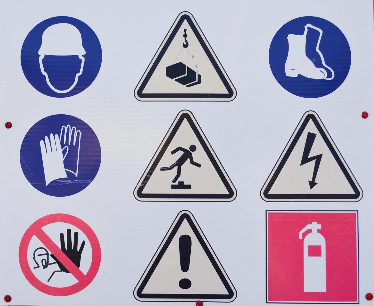 A board with warning signs about danger that stands before the start of construction on the field photo