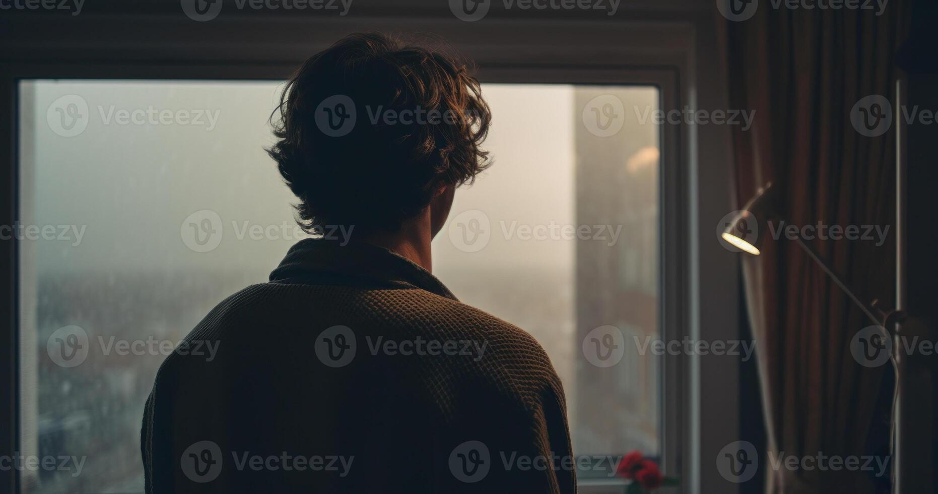 Person Looking Out Rainy Window On Gloomy Day. Contemplative Man. photo