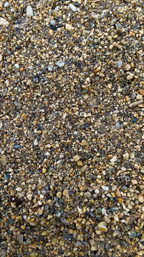Texture of yellow sand with small pebbles. Sand pattern photo