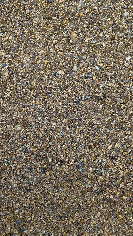 Texture of yellow sand with small pebbles. Sand pattern photo