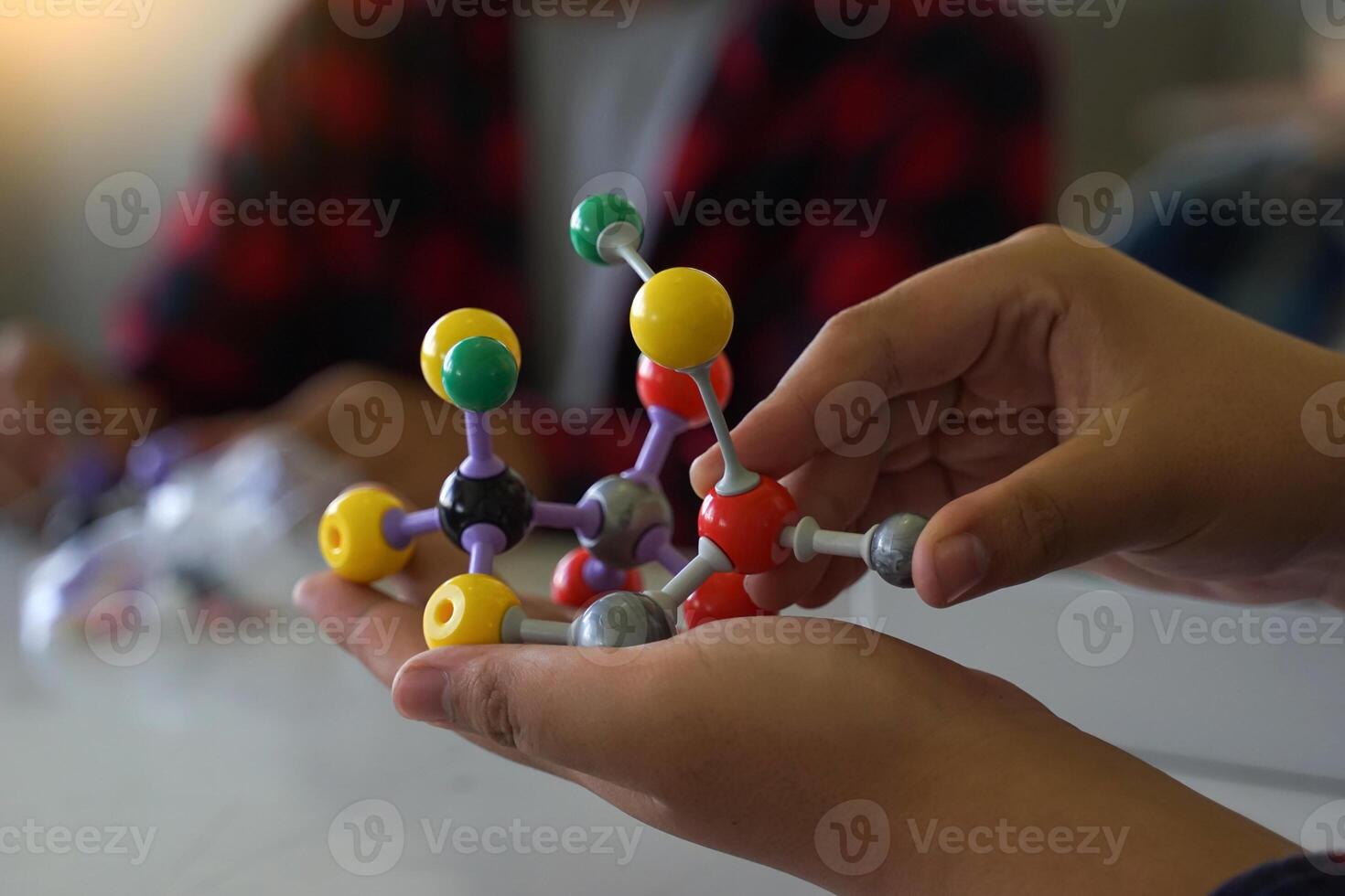 Hand holding a Simulate Shape of covalent molecules on a gray and white background. photo