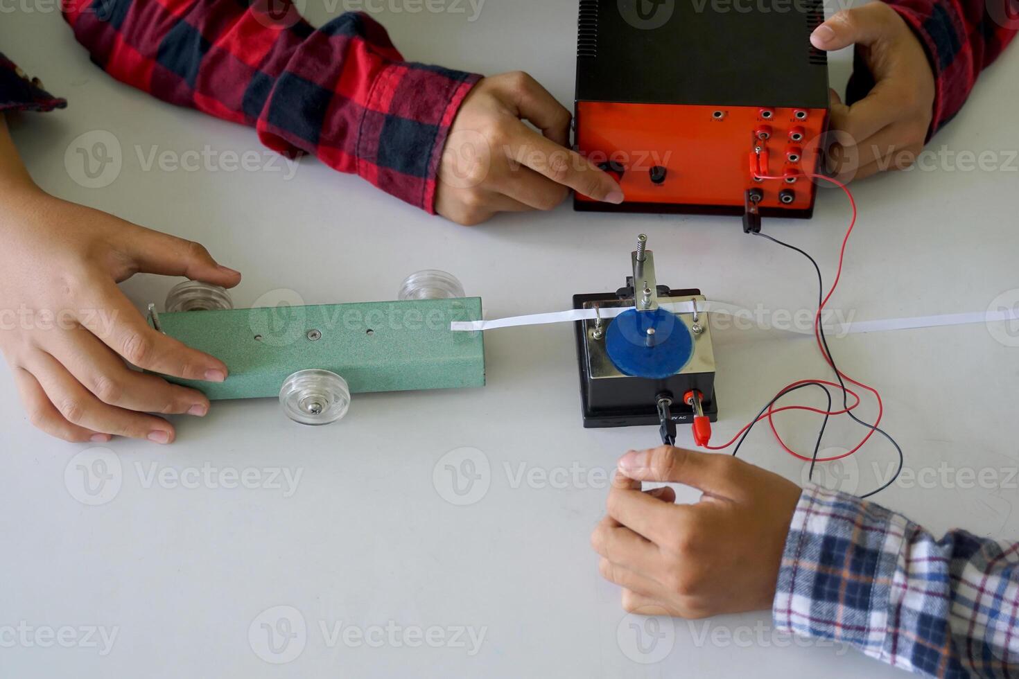 Science classroom, students are conducting a physics experiment on the speed of objects using a ticker timer device. Concept of science classroom, science skills, learning, science experiment. photo
