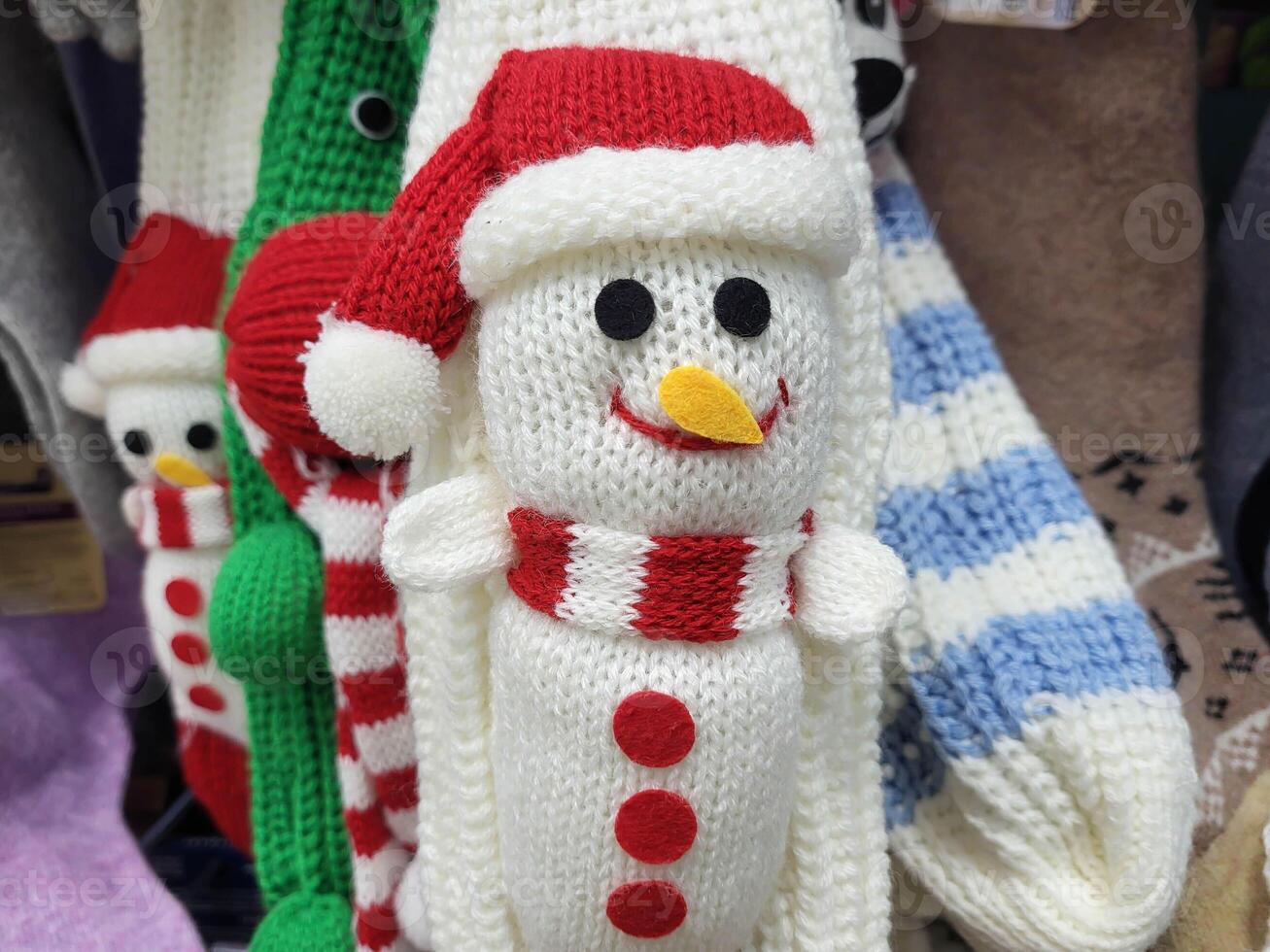 There are knitted white mittens with a snowman hanging in the store. The concept of Christmas and New Year. photo