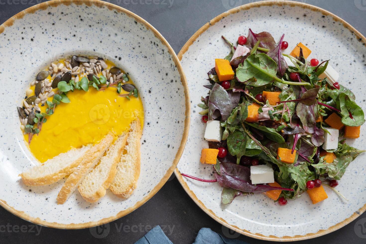 Pumpkin puree soup and pumpkin salad top view, flat lay. Autumn menu concept photo
