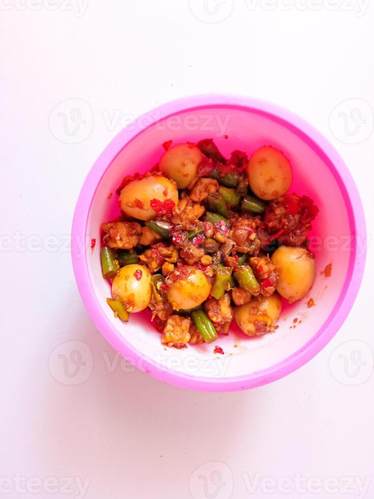 a bowl of balado quail eggs and tempeh ready to eat isolate on white photo