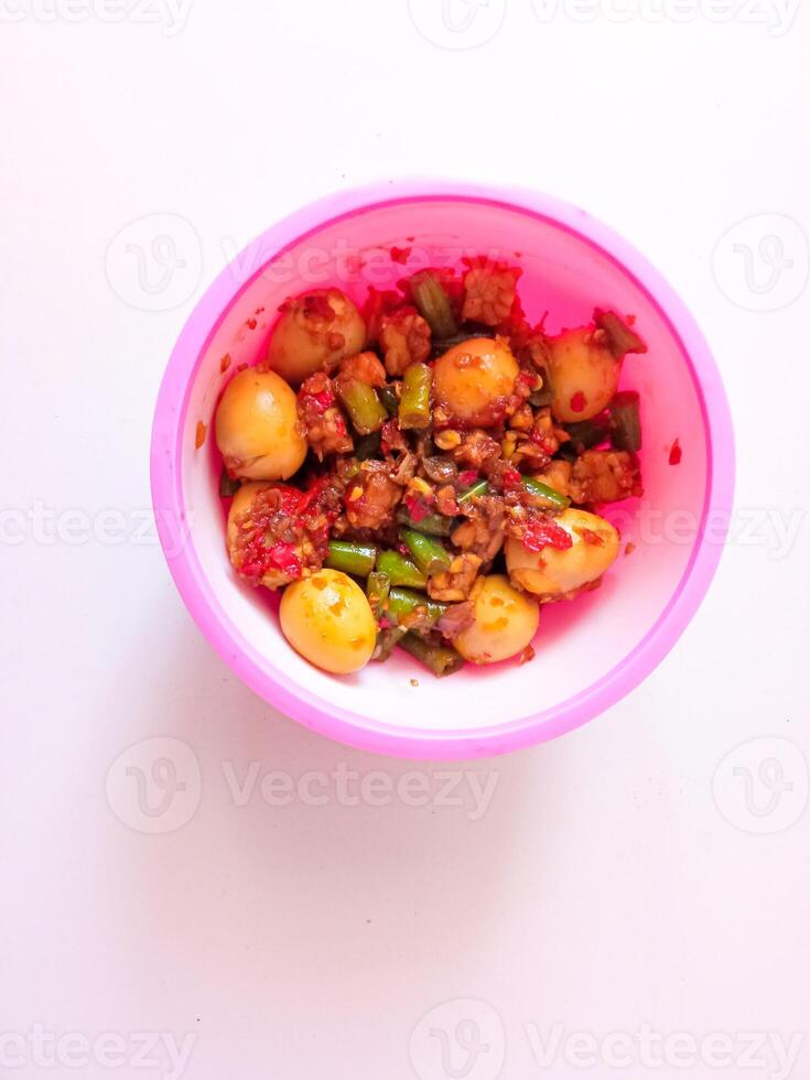 a bowl of balado quail eggs and tempeh ready to eat isolate on white photo