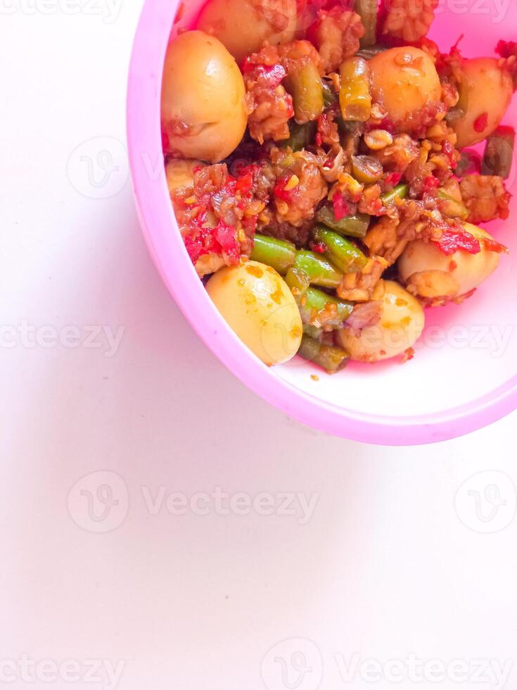 a bowl of balado quail eggs and tempeh ready to eat isolate on white photo