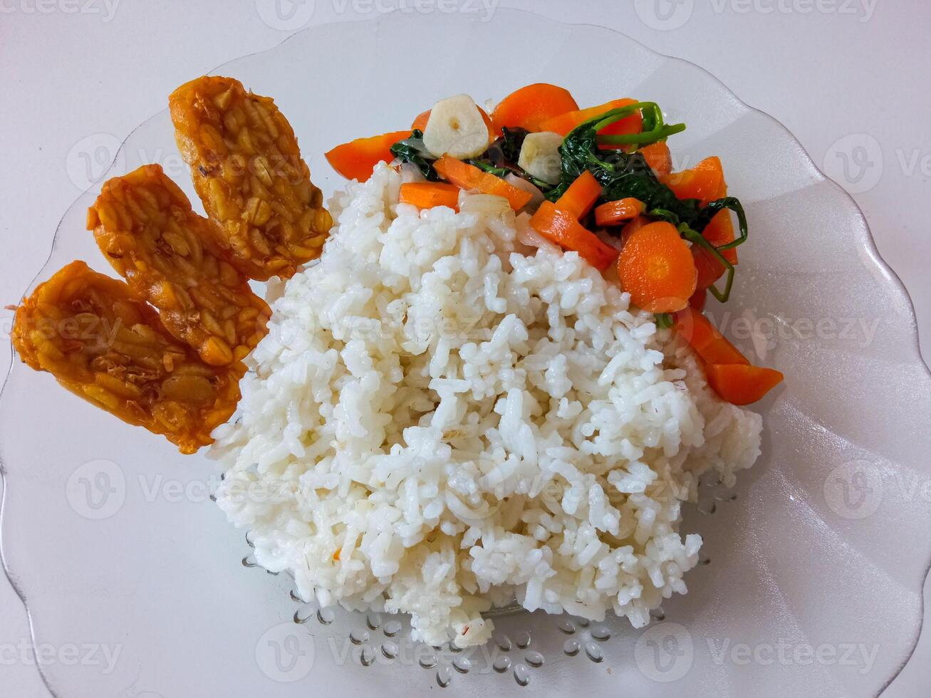 a plate of rice with tempeh and vegetables ready to eat isolate on white photo